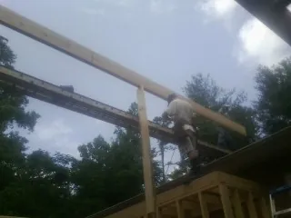 Carpenter setting a ridge beam over a new addition frame — Ice Dam Removal by Roofing Brothers in Judsonia