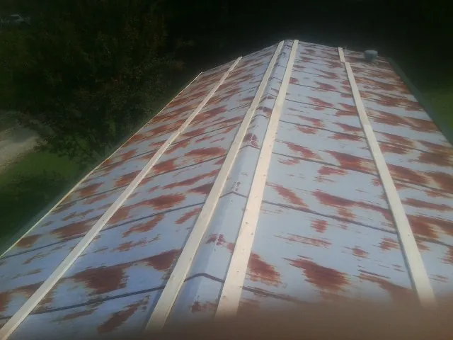 Rusted metal roof panels with new wood purlins before replacement — Storm Damage Roof Repair in Judsonia by Roofing Brothers