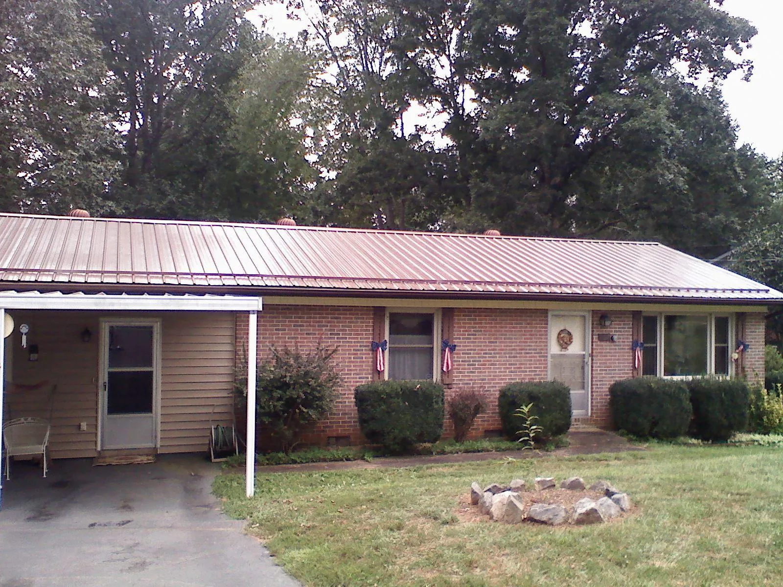Bronze metal roof and carport on a brick ranch home — Roof Repair work by our crew in Judsonia